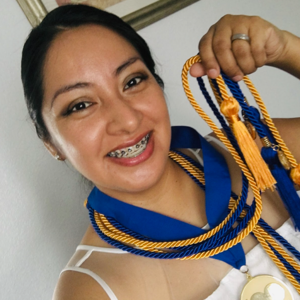 Photo of Berenice displaying her medal and cords