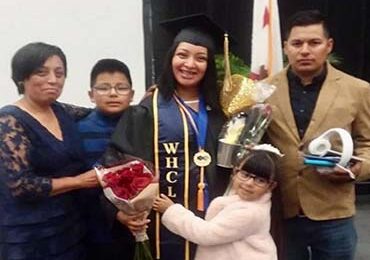 Photo of Berenice (middle) with her family on her graduation