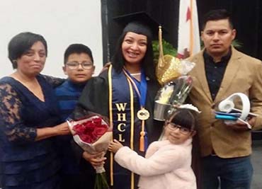 Photo of Berenice (middle) with her family on her graduation